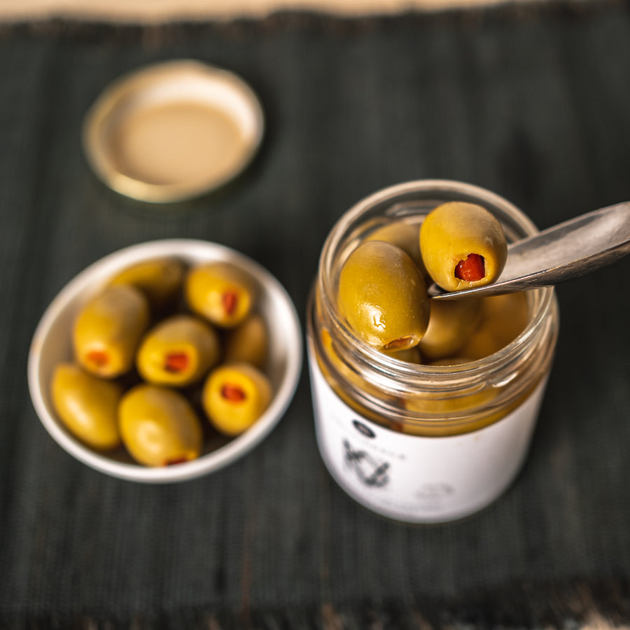 Grüne Oliven mit Paprika gefüllt in Salzlake
